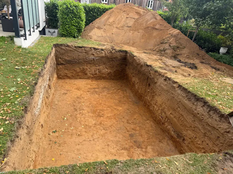 Ausgehobene Baugrube für einen Swimmingpool im Privatgarten