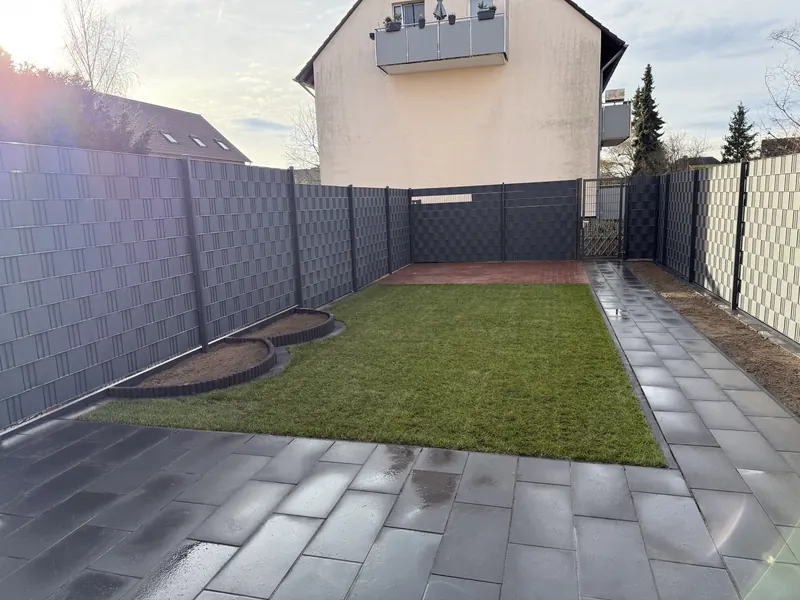 Neu angelegter Garten mit Rollrasen, Plattenterrasse, Rundbeet und Sichtschutzzaun